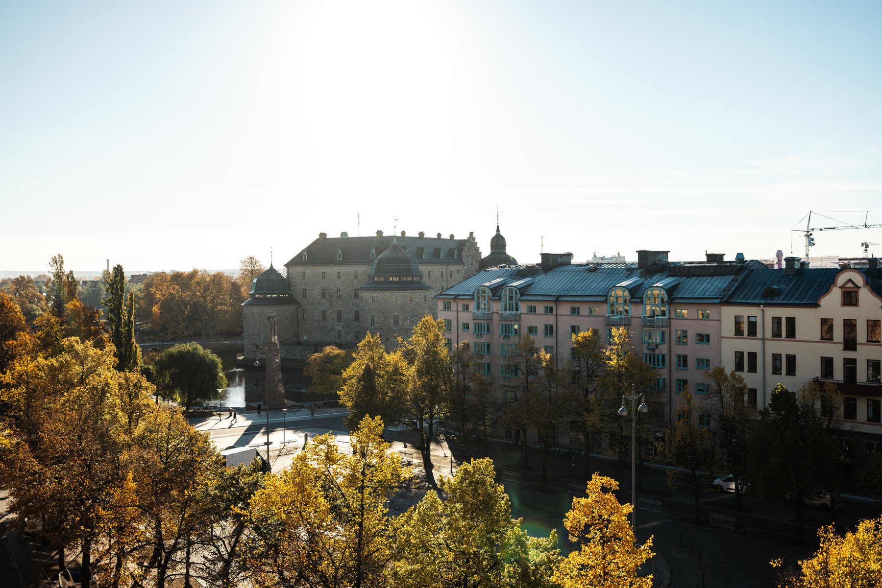 Utsikt från balkongen över trädtopparna mot Örebro slott